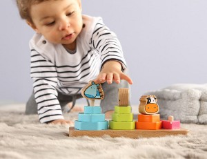 Kleinkind greift mit der linken Hand nach seinem Spielzeug