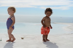 Zwei Kleinkinder in Schwimmkleidung am Strand